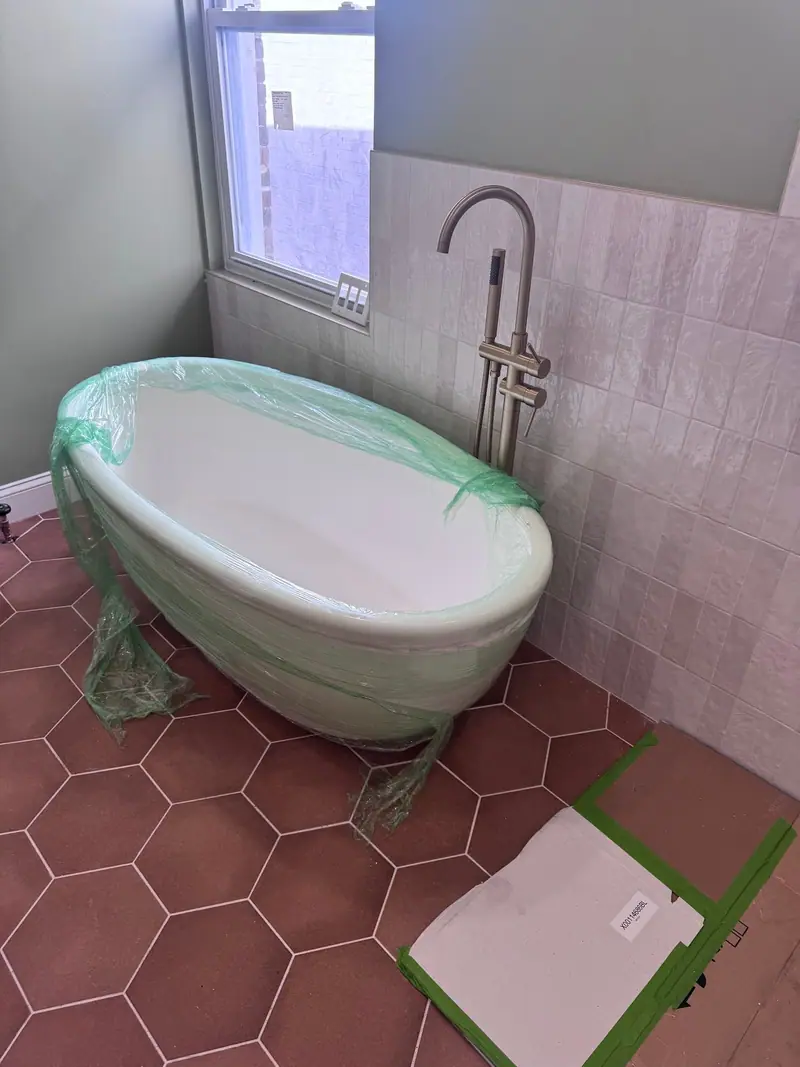 Freestanding tub with a floor mounted filler on hex tile