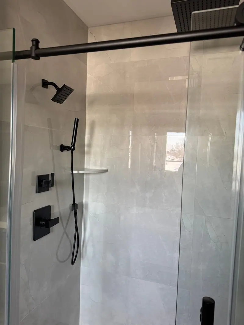 Shower with matte black trim and hand shower